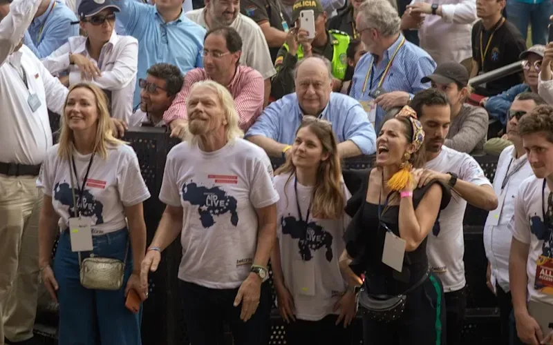 Richard Branson in pink tshirt standing in a crowd for Live Aid