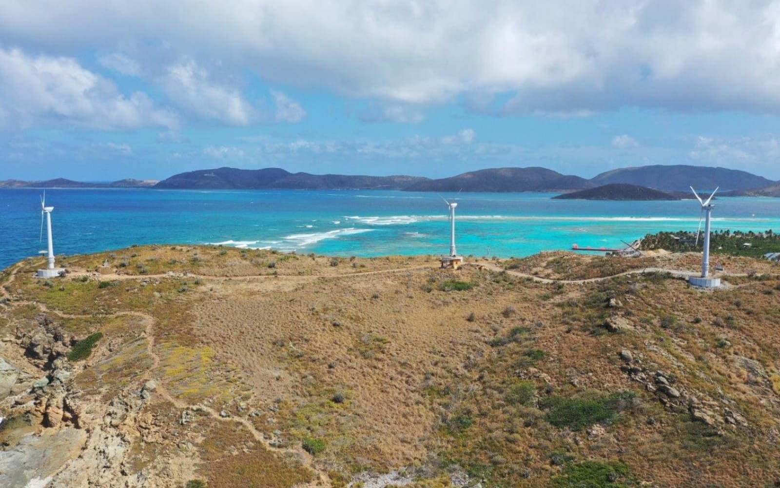 Wind turbines on Necker Island, with the ocean and islands in the background