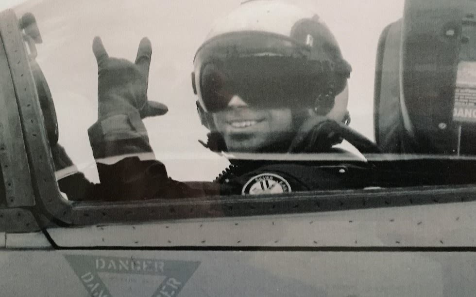 Virgin Galactic pilot Patrick Moran waves form inside a military aircraft