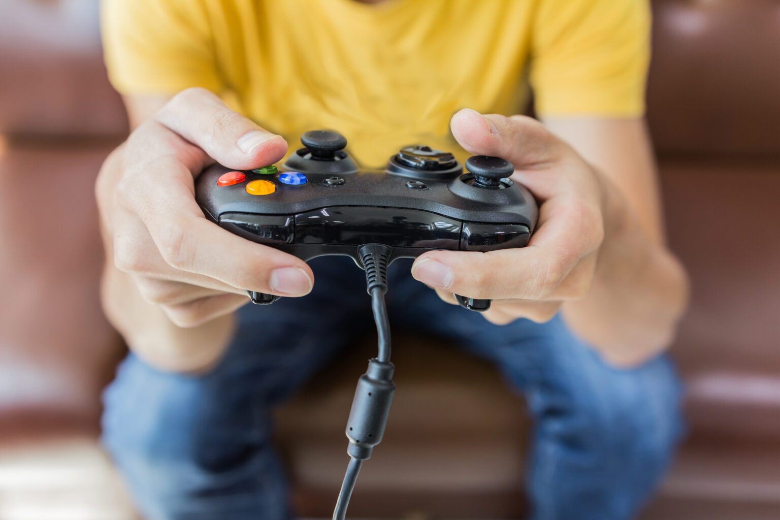 A man's hands holding a gaming controller
