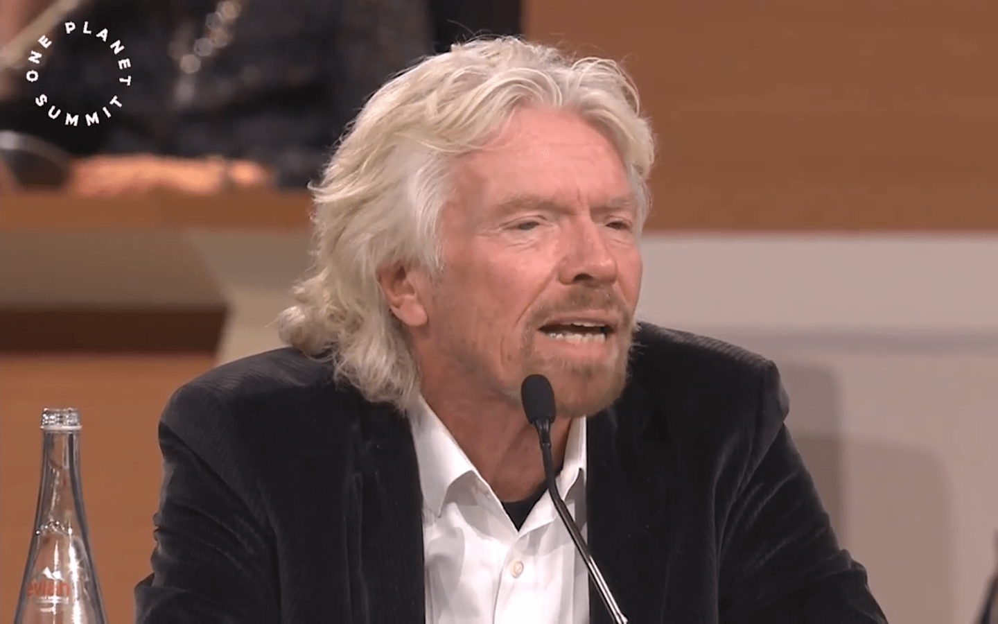 Richard Branson sitting down at a table speaking at the summit