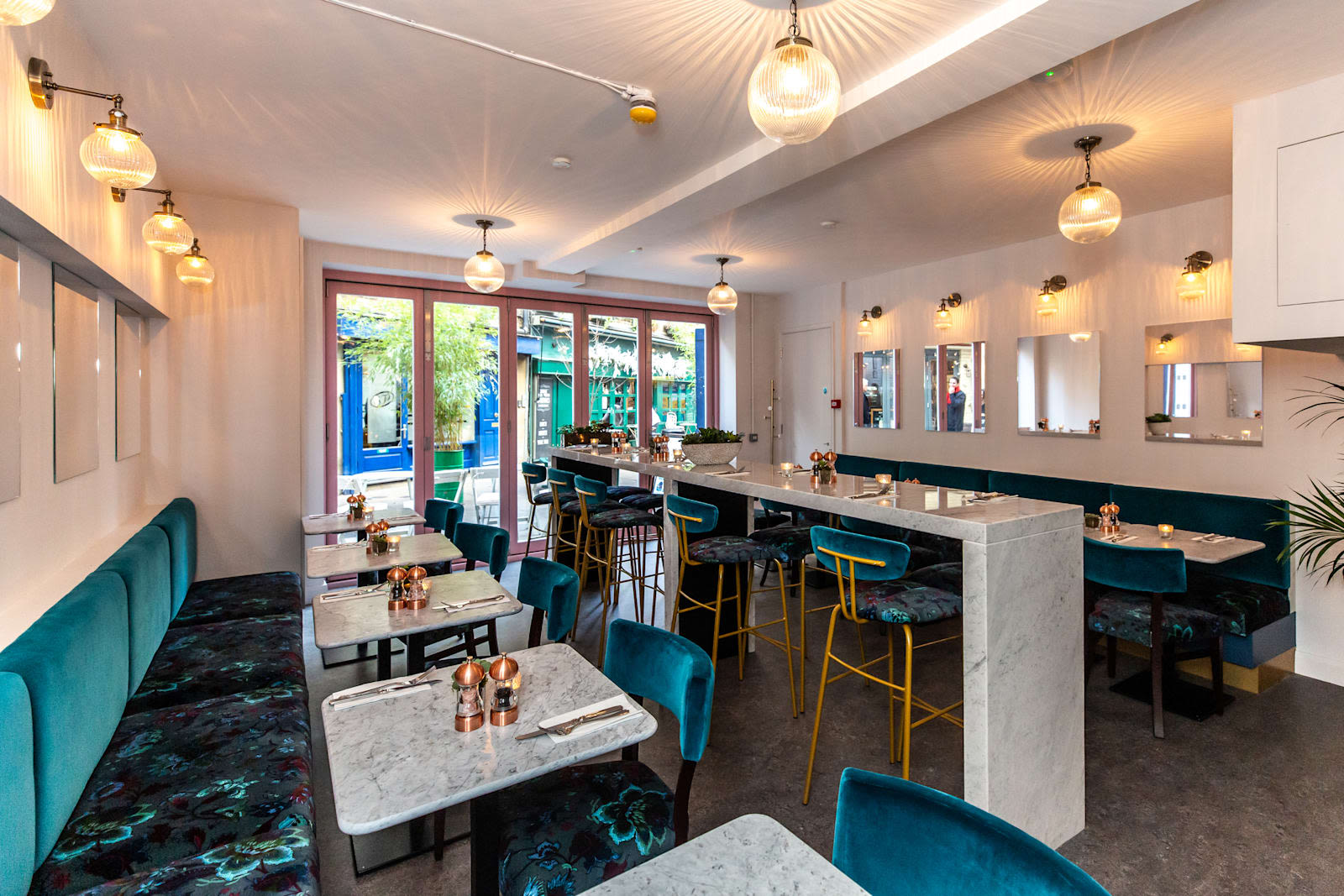 The Redemption bar with blue velvet seats and copper accessories on table