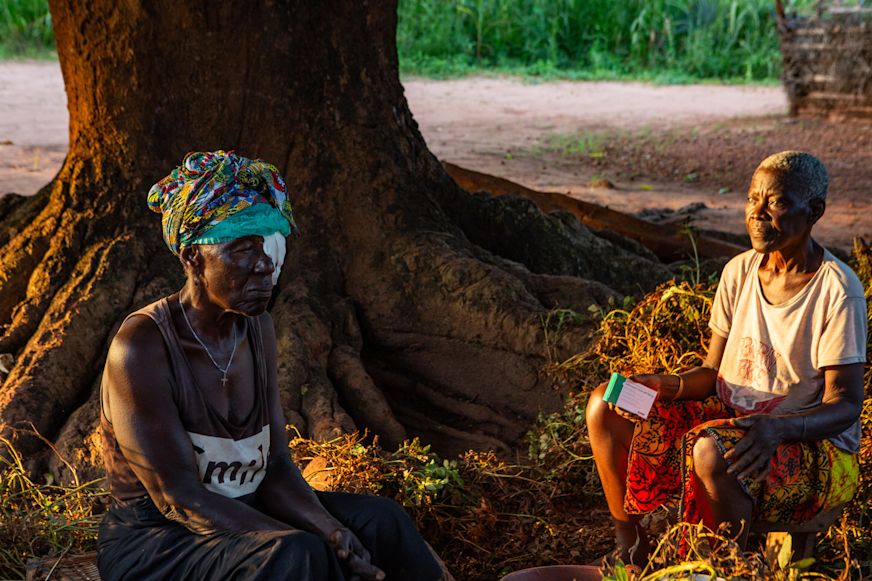 Domingus holds medication and looks at Nene following her trachoma surgery which was carried out at their home | Sightsavers/Alyssa Mariner