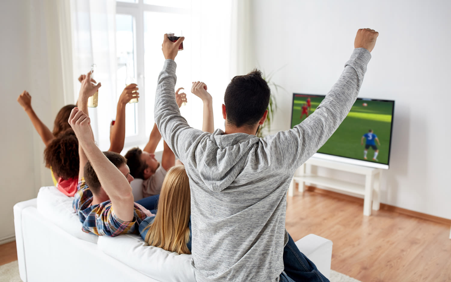 A group of friends watching a football match on television together