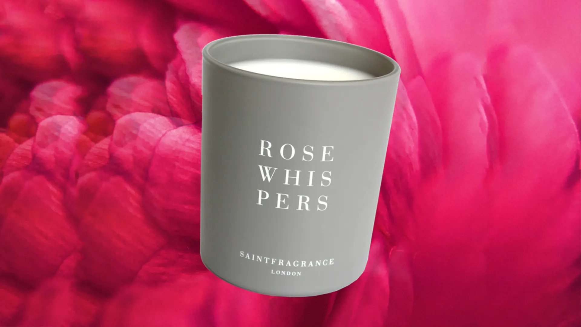 Saint Fragrance Rose Whispers scented candle on a pink petal background