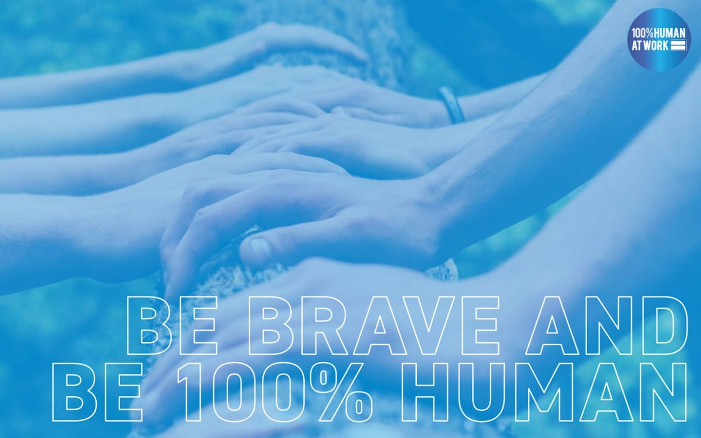 Many hands resting on a tree branch, with the words 'Be brave and be 100% human' written over them