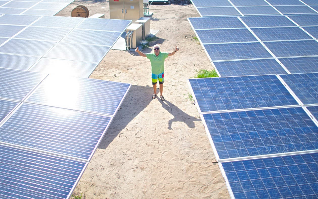 Richard Branson next to solar panels 