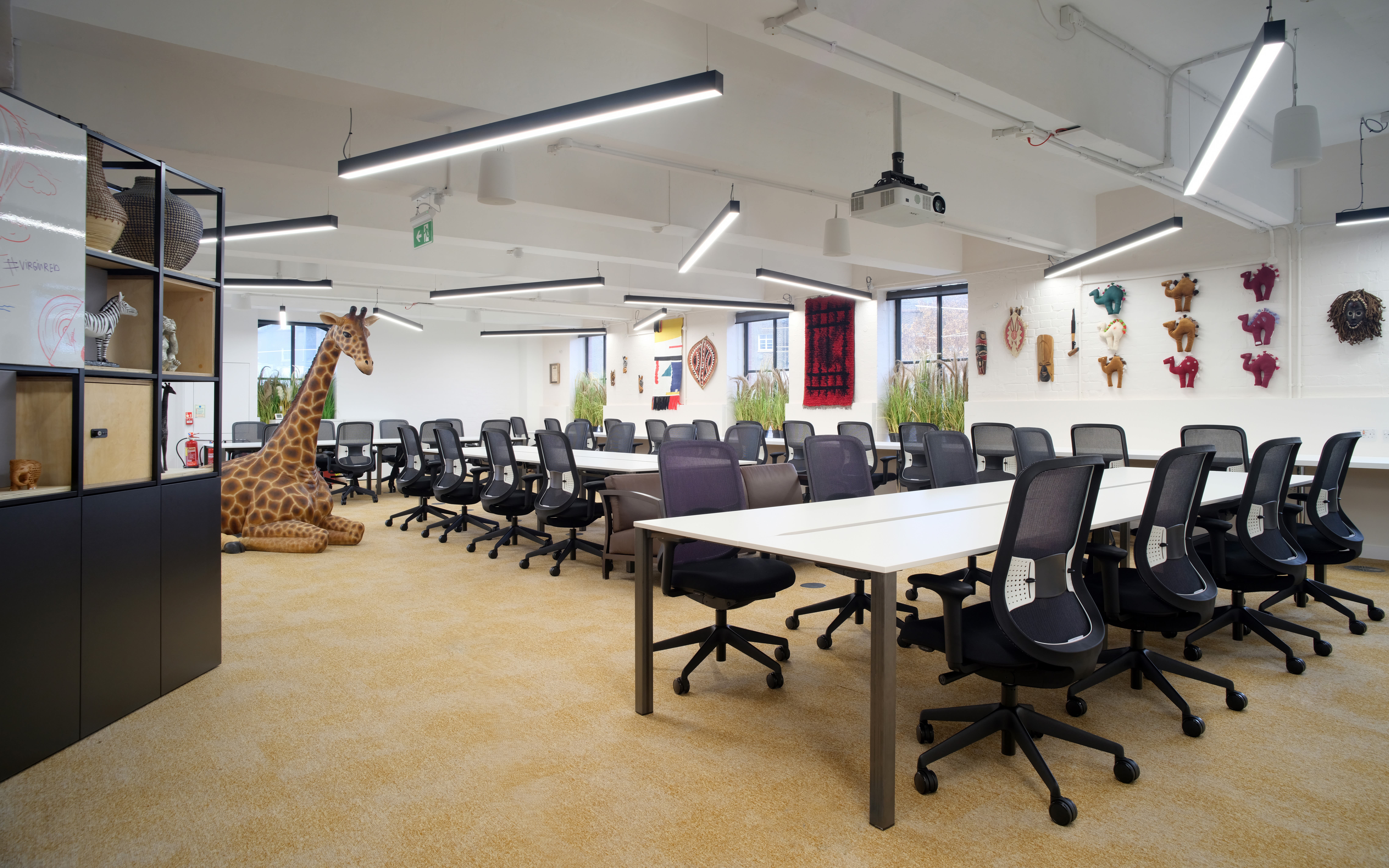 The inside of an office at Virgin Red showing desks and chairs and a large model of a giraffe