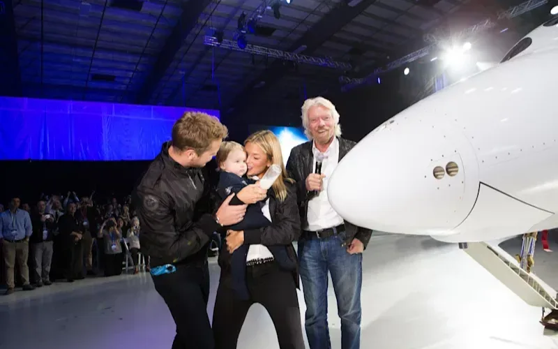 Richard Branson with his son Sam Branson, daughter-in-law Bellie Branson and granddaughter Eva-Deia at the unveiling of VSS Unity smashing a bottle of milk on the nose of the spacecraft