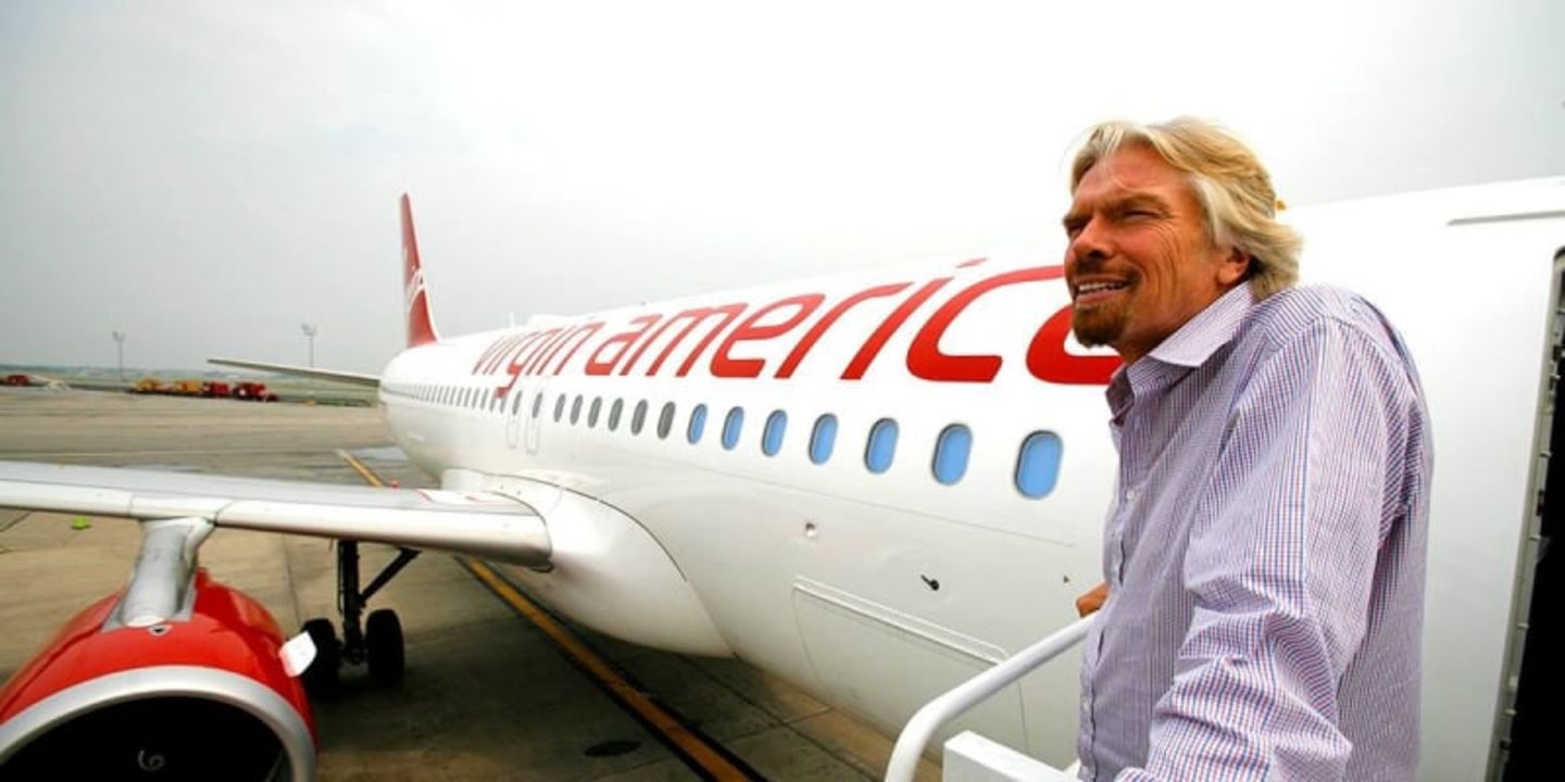 Richard Branson in front of a Virgin America plane