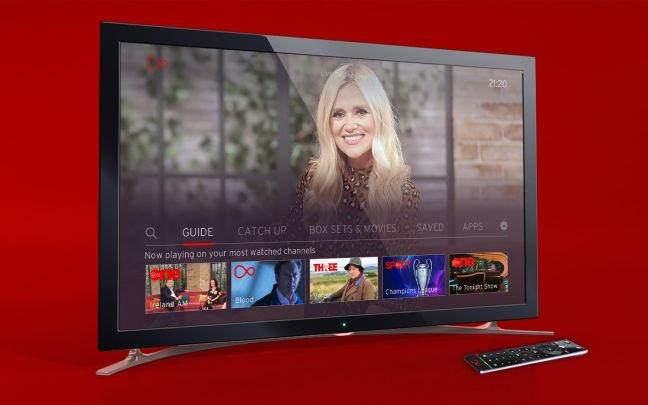 A television with a remote control next to it on a red background