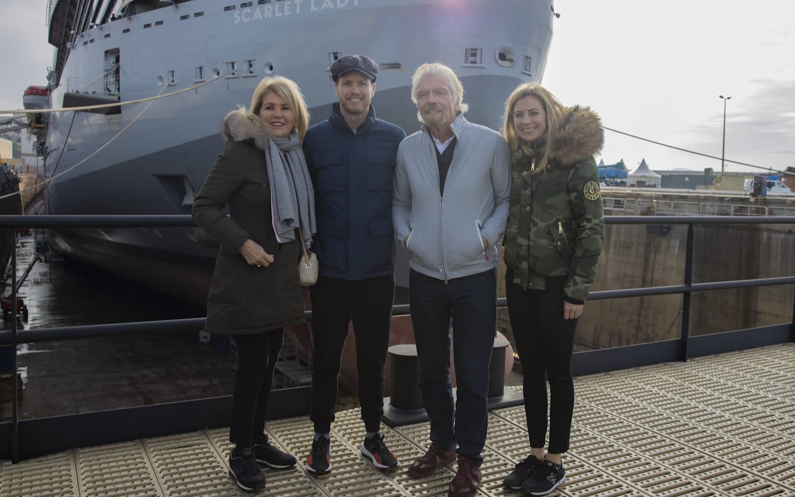 Richard Branson, wife Joan and children Sam and Holly stand on the dock in front of Virgin Voyages' ship Scarlet Lady
