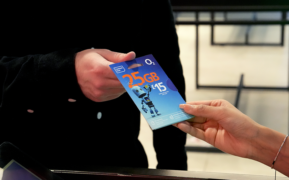 An O2 employee giving a customer a free National Databank SIM card