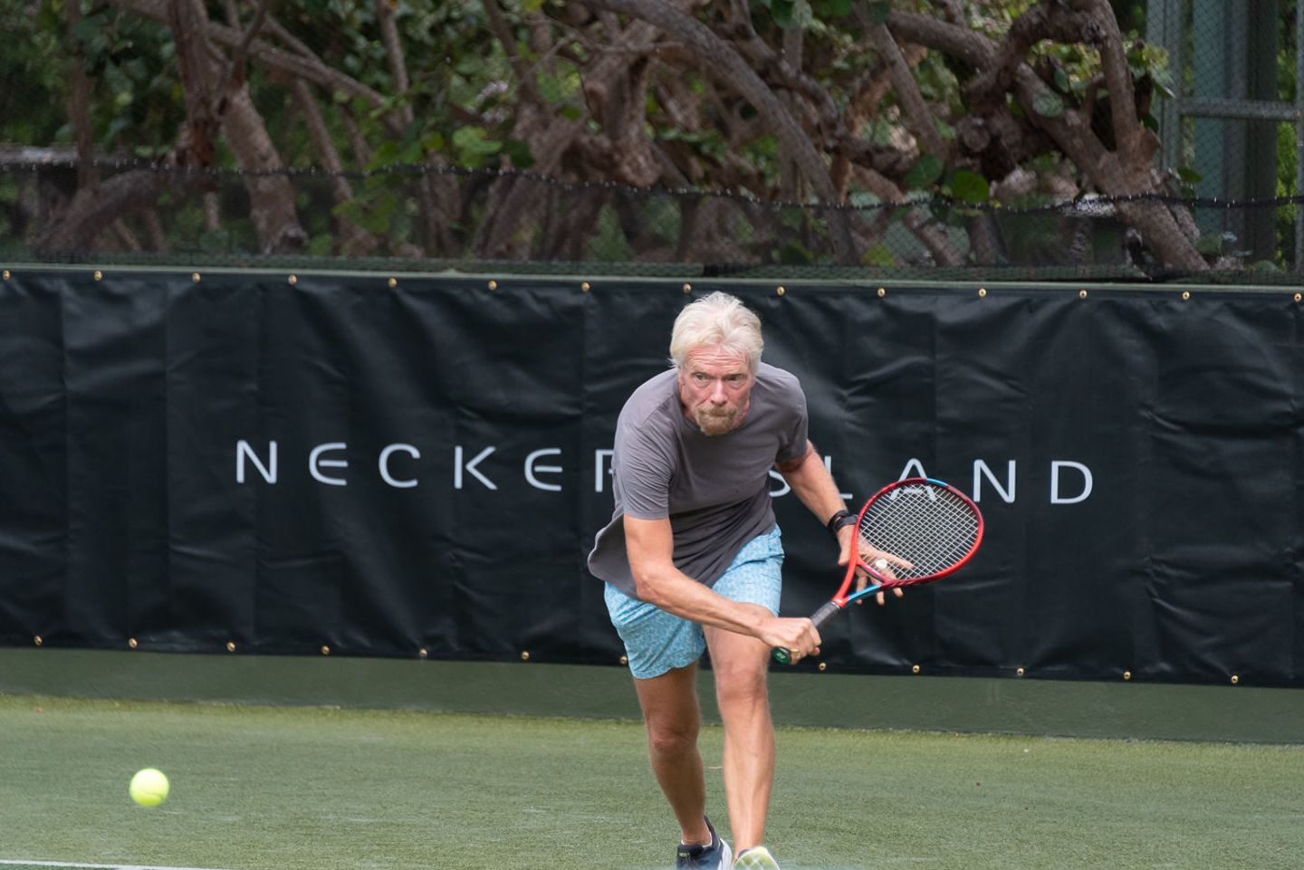Richard Branson playing tennis at the 2022 Necker Cup