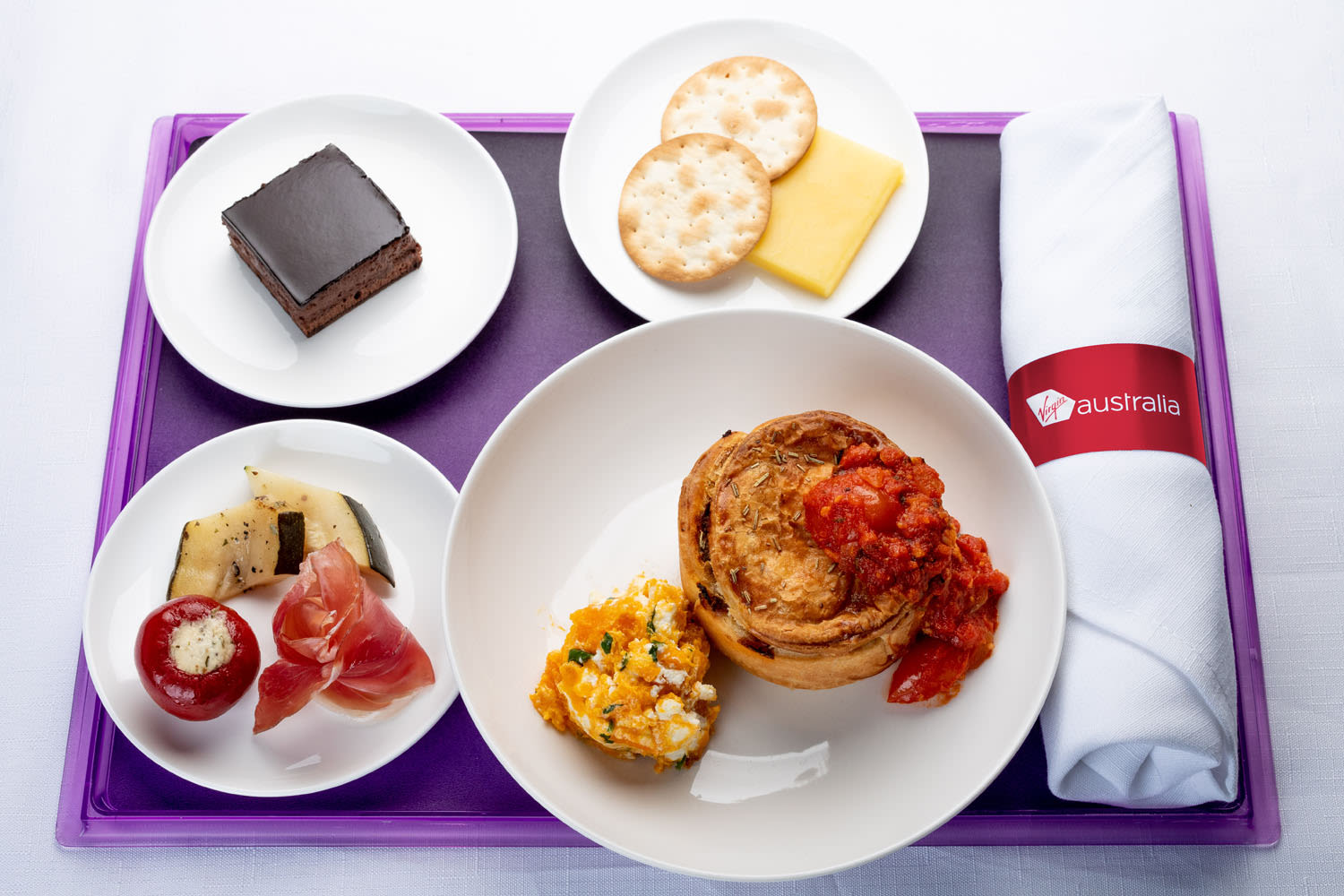 Lamb and rosemary pie with a pumpkin and feta smash, served alongside an antipasto plate with prosciutto, cheese and crackers chocolate delight cake Business Class offering Virgin Aus