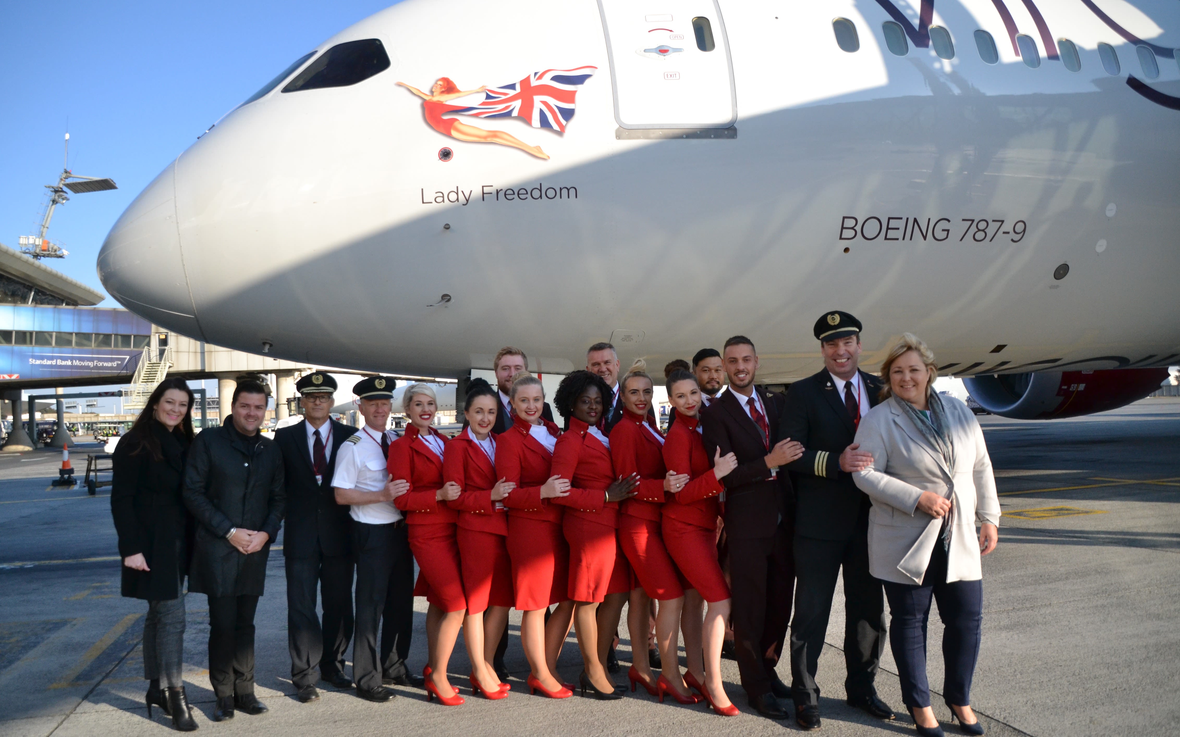 Cabin crew standing in front of a Virgin Atlantic plane called Lady Freedom