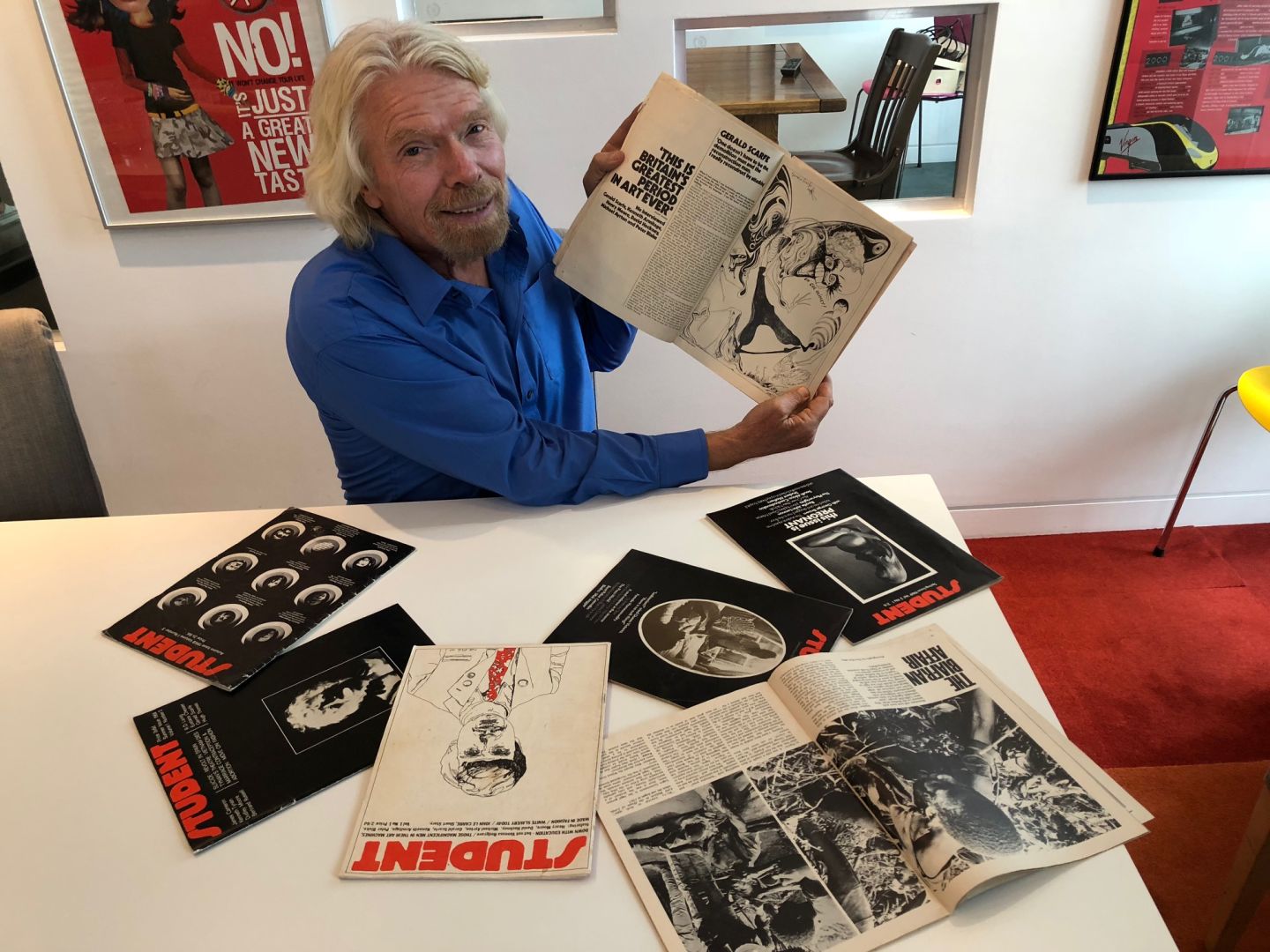 Richard Branson holding up old editions of Student Magazine