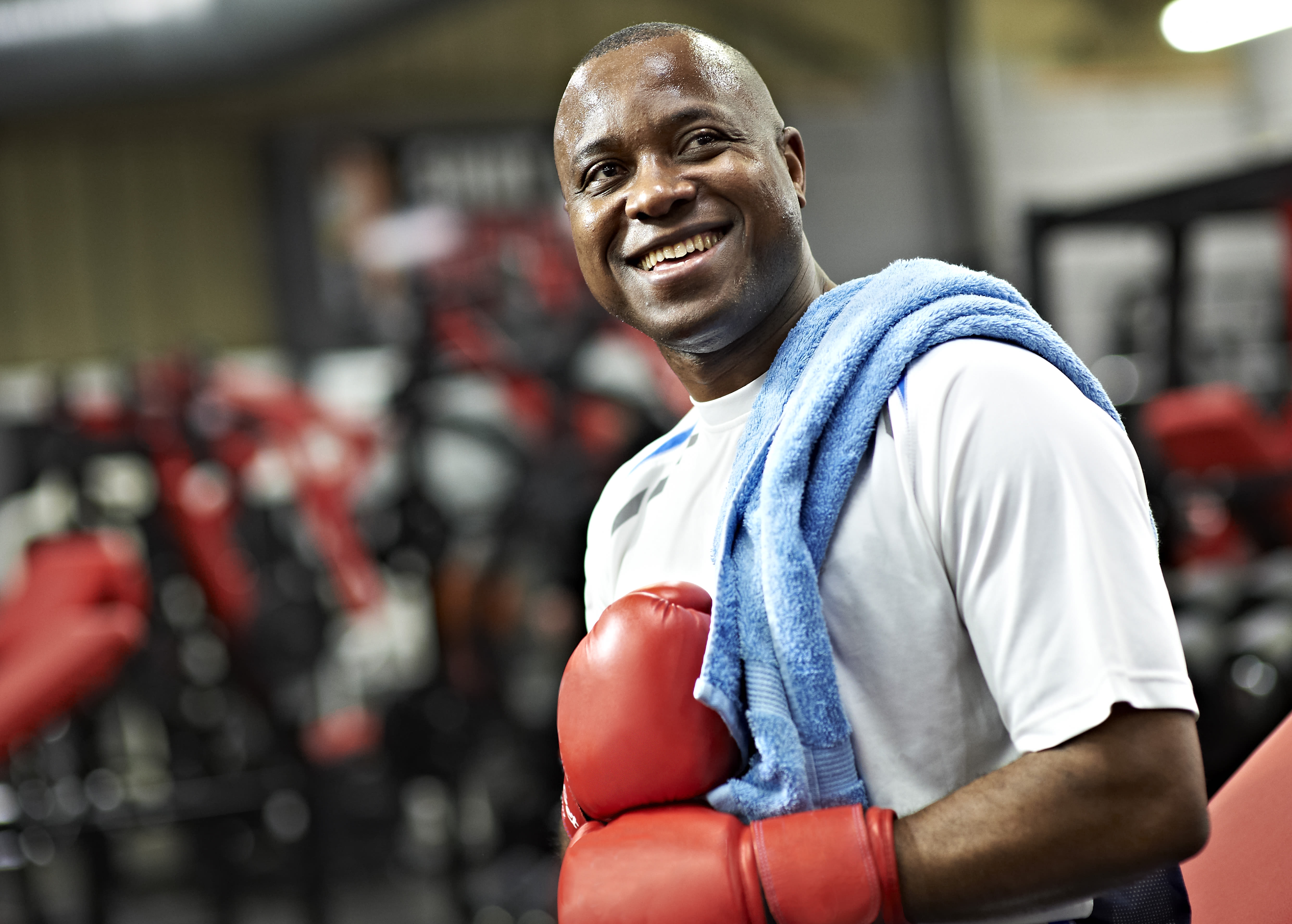 Man smiling in red boxing gloves. 