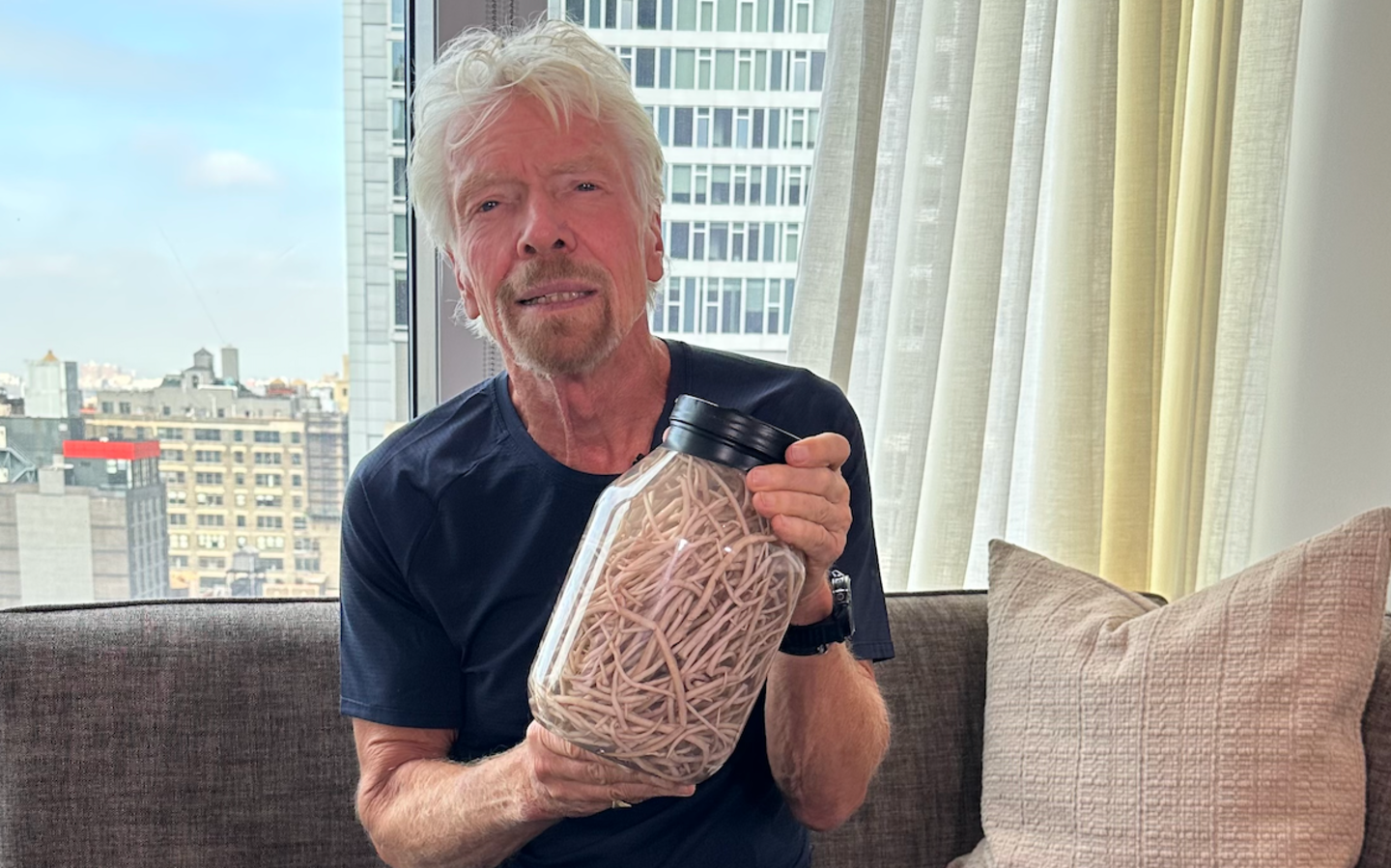 Richard Branson holding up 200 parasitic worms with The END Fund