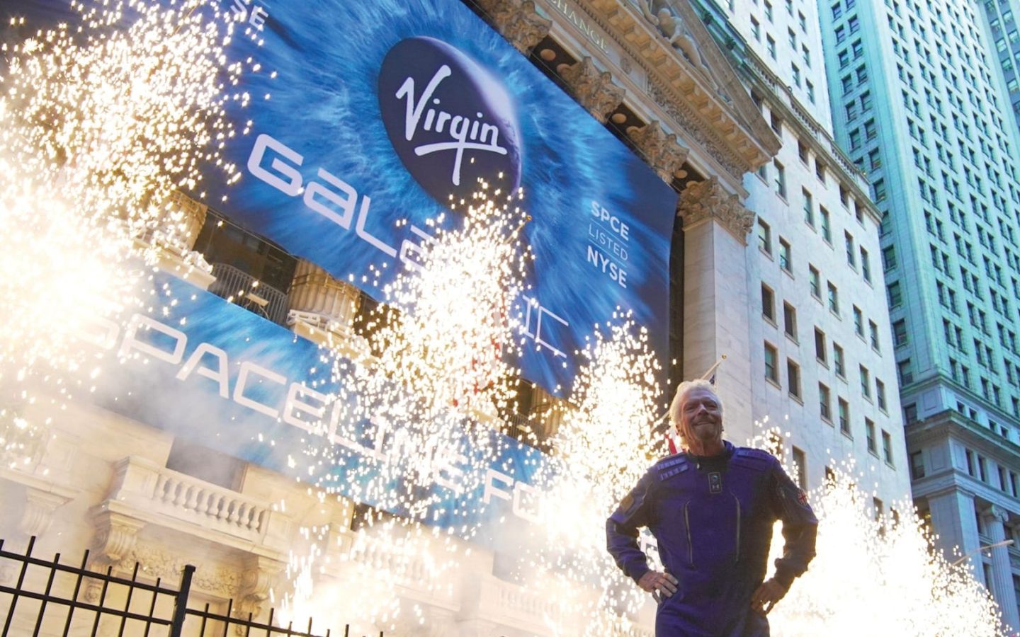 Richard Branson stands in front of pyrotechnics celebrating Virgin Galactic's debut on the New York Stock Exchange