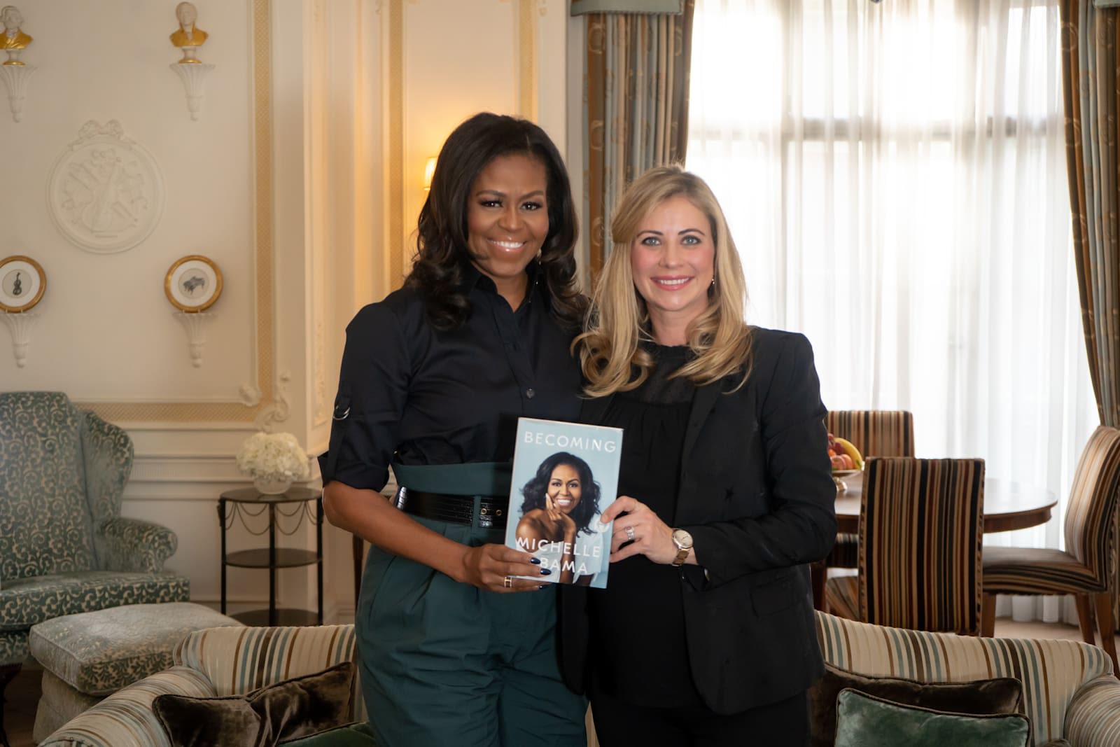 Michelle Obama and Holly Branson holding a copy of Michelle's book, Becoming