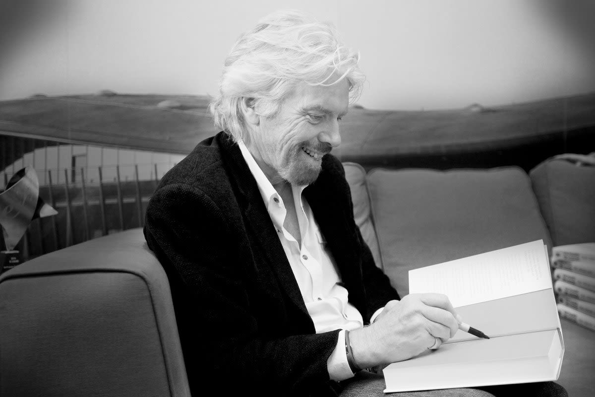 Black and white image of Richard Branson writing 