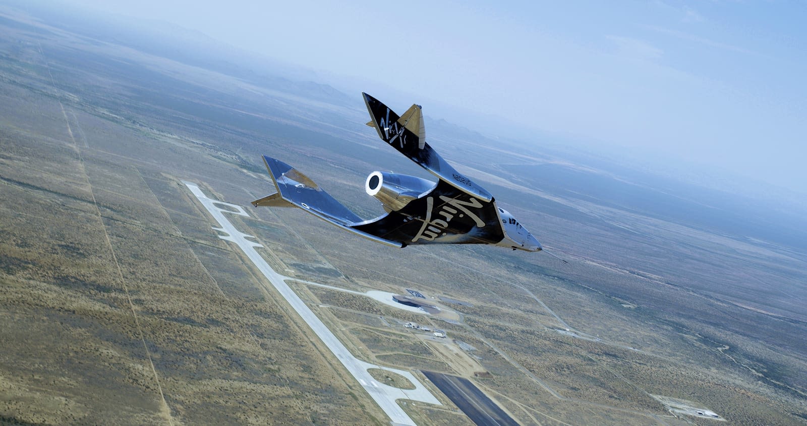 Virgin Galactic flying across land with blue sky