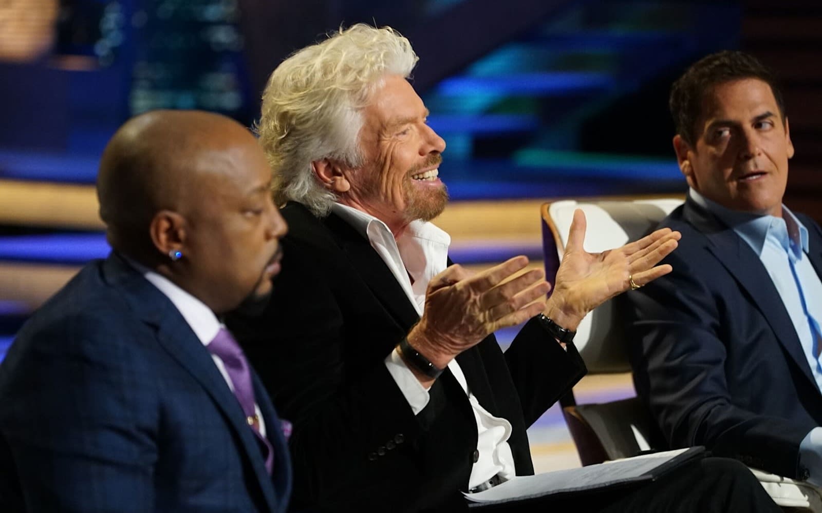 Richard Branson on the Shark Tank judging panel sitting between Mark Cuban and Daymond John