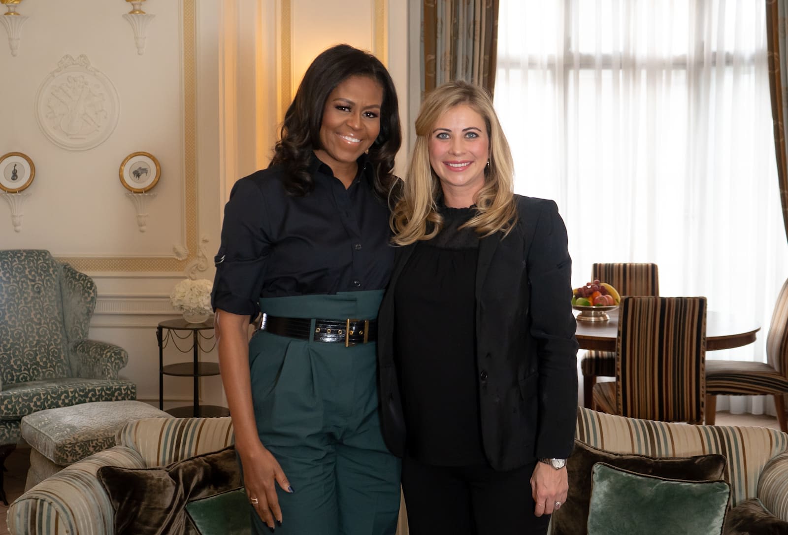 Holly Branson standing next to Michelle Obama, both facing the camera and smiling