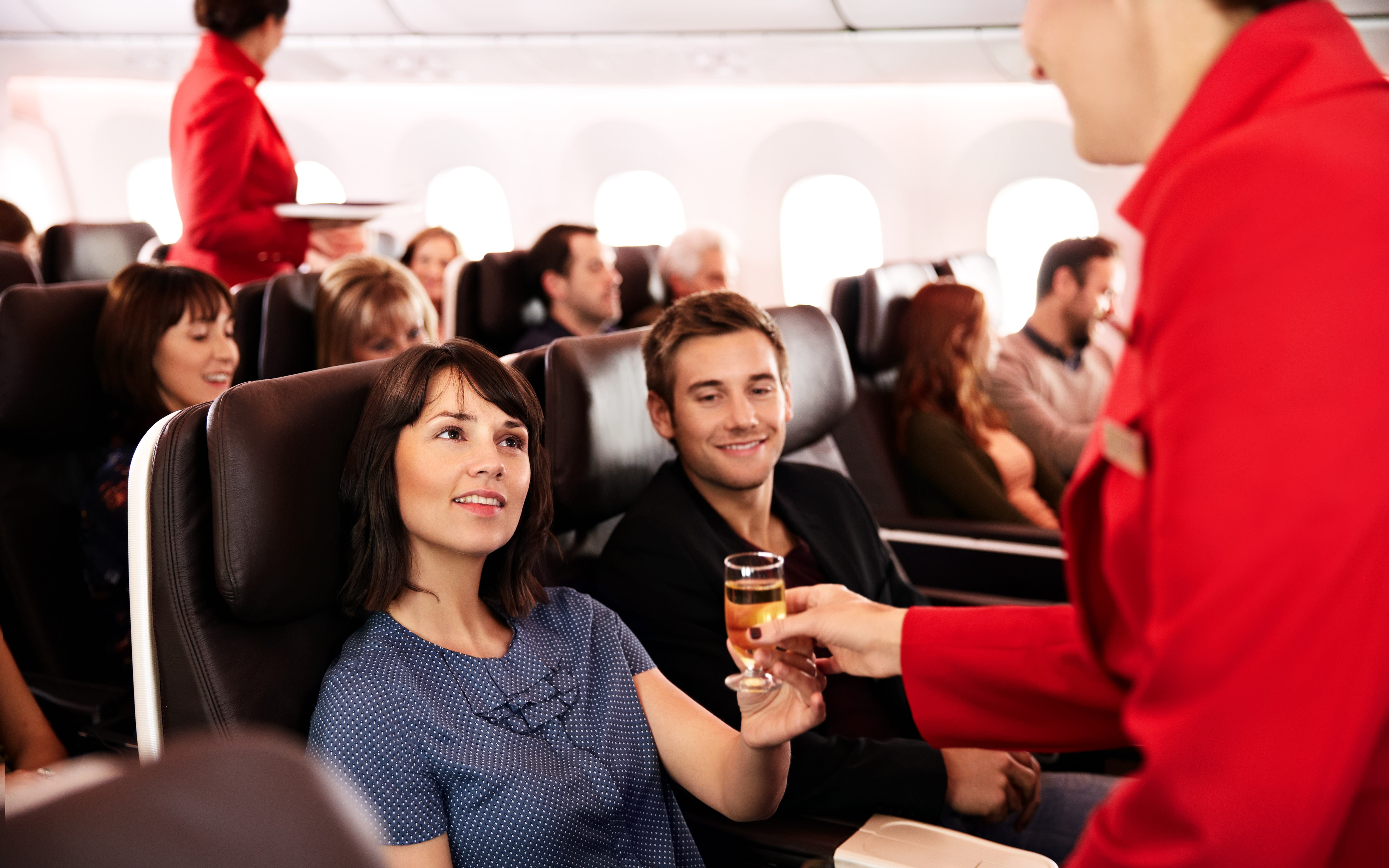 Image of a couple being served a drink in Premium Economy of a Virgin Atlantic Flight.