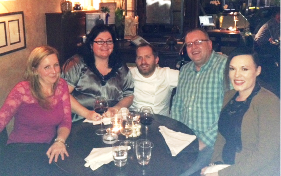 A group of Virgin Trains team smile around a dinner table