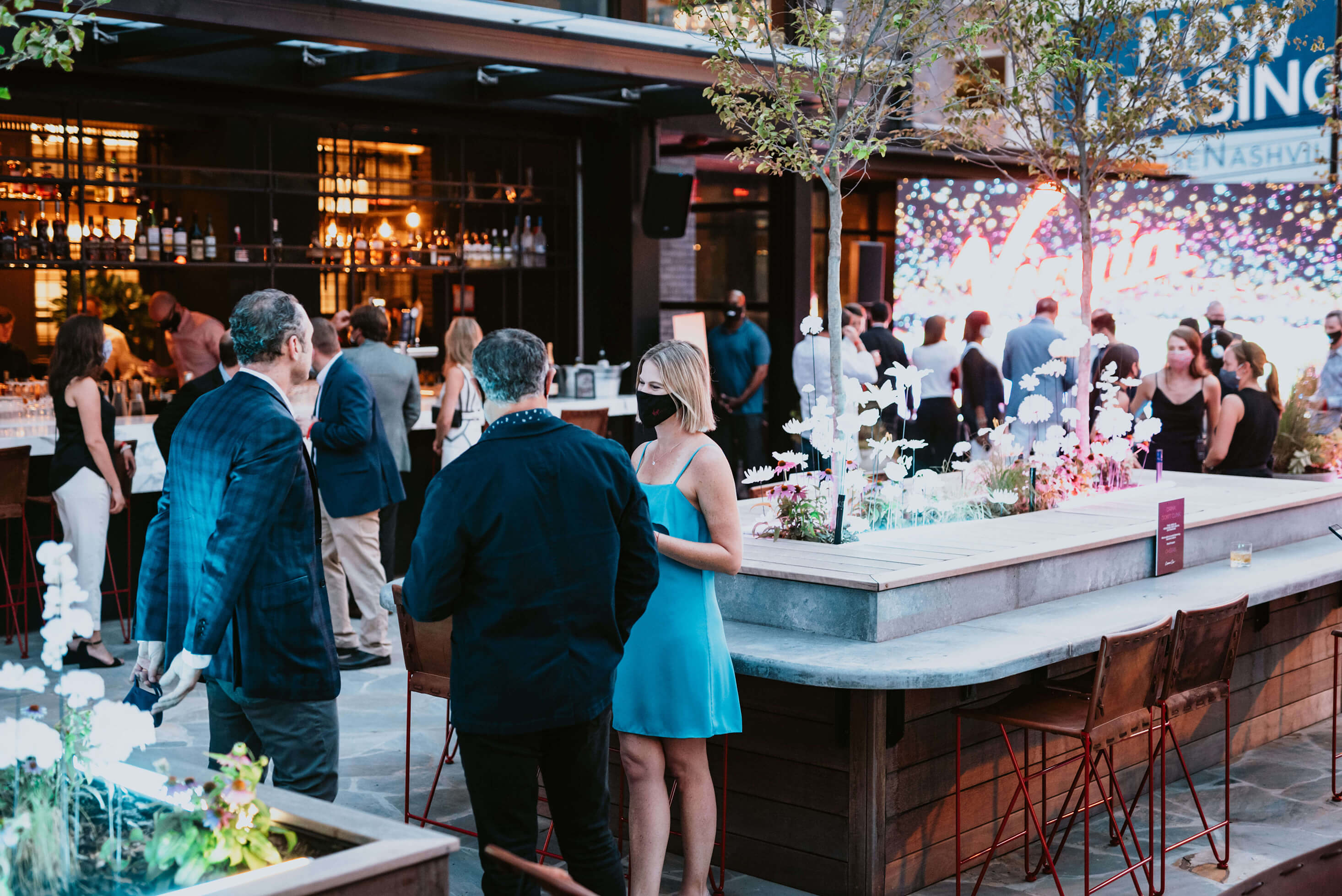 People at a bar at Virgin Hotels Nashville wearing facemasks