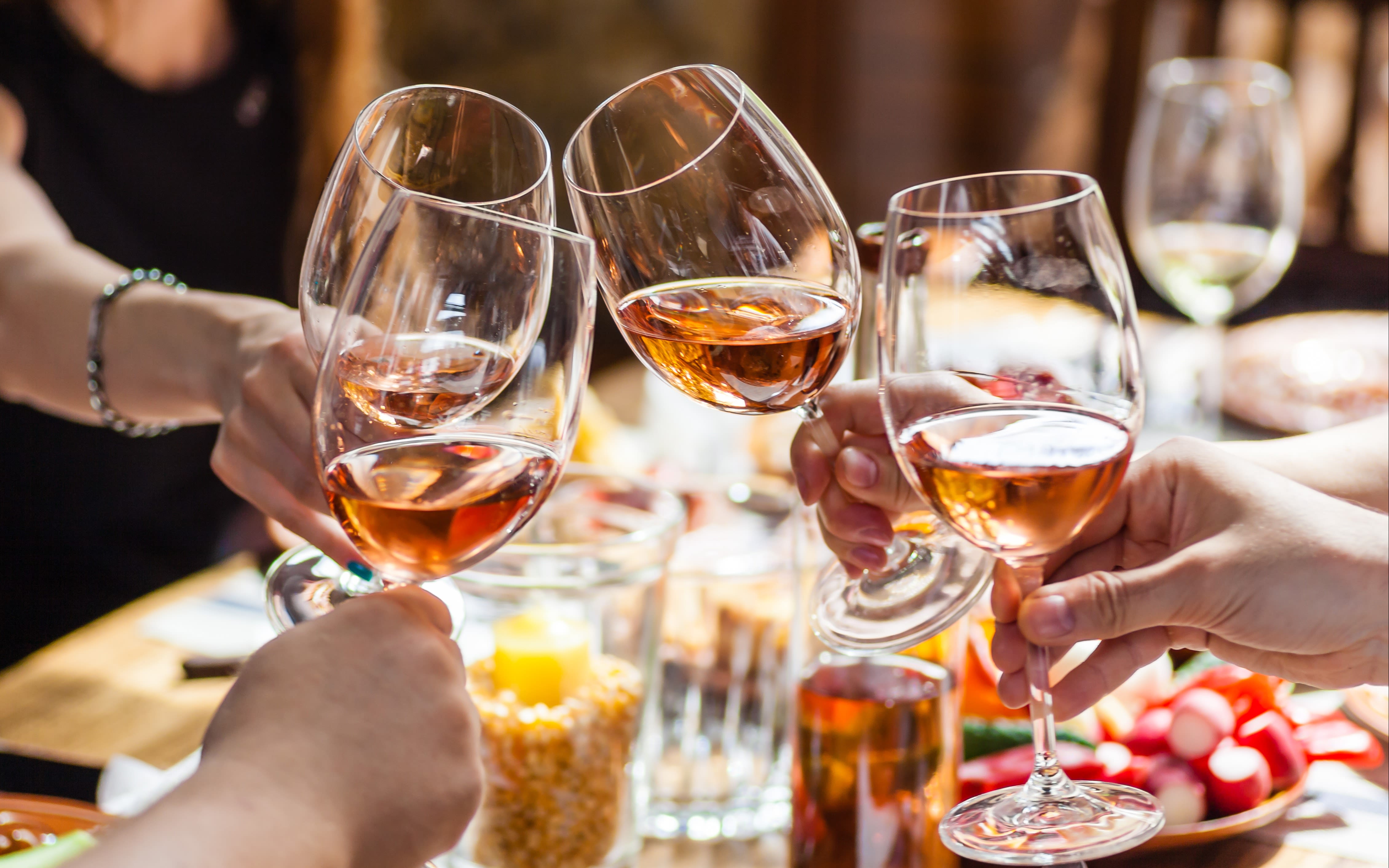 An image of people holding glasses of rosé wine