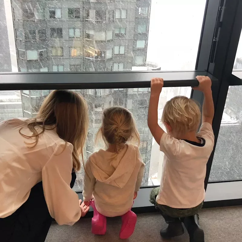 Holly Branson looking out of a window with her two young children in New York, 2018