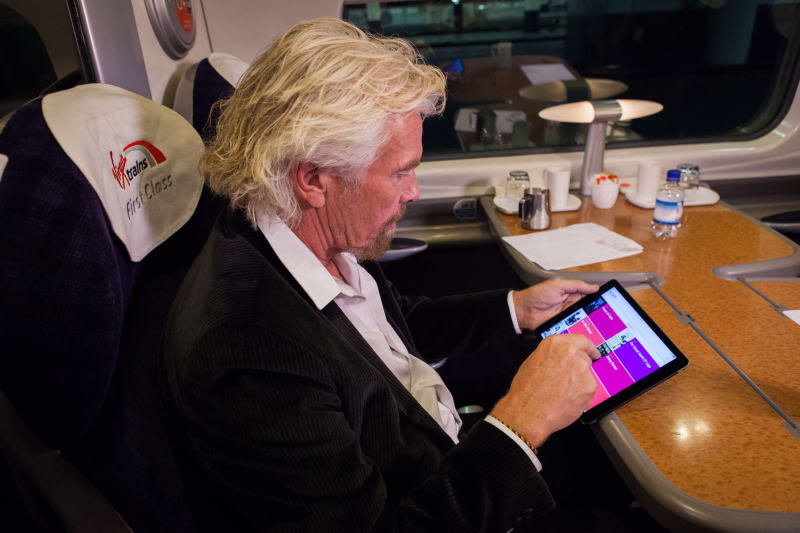 Richard Branson on his iPad on a Virgin Trains journey