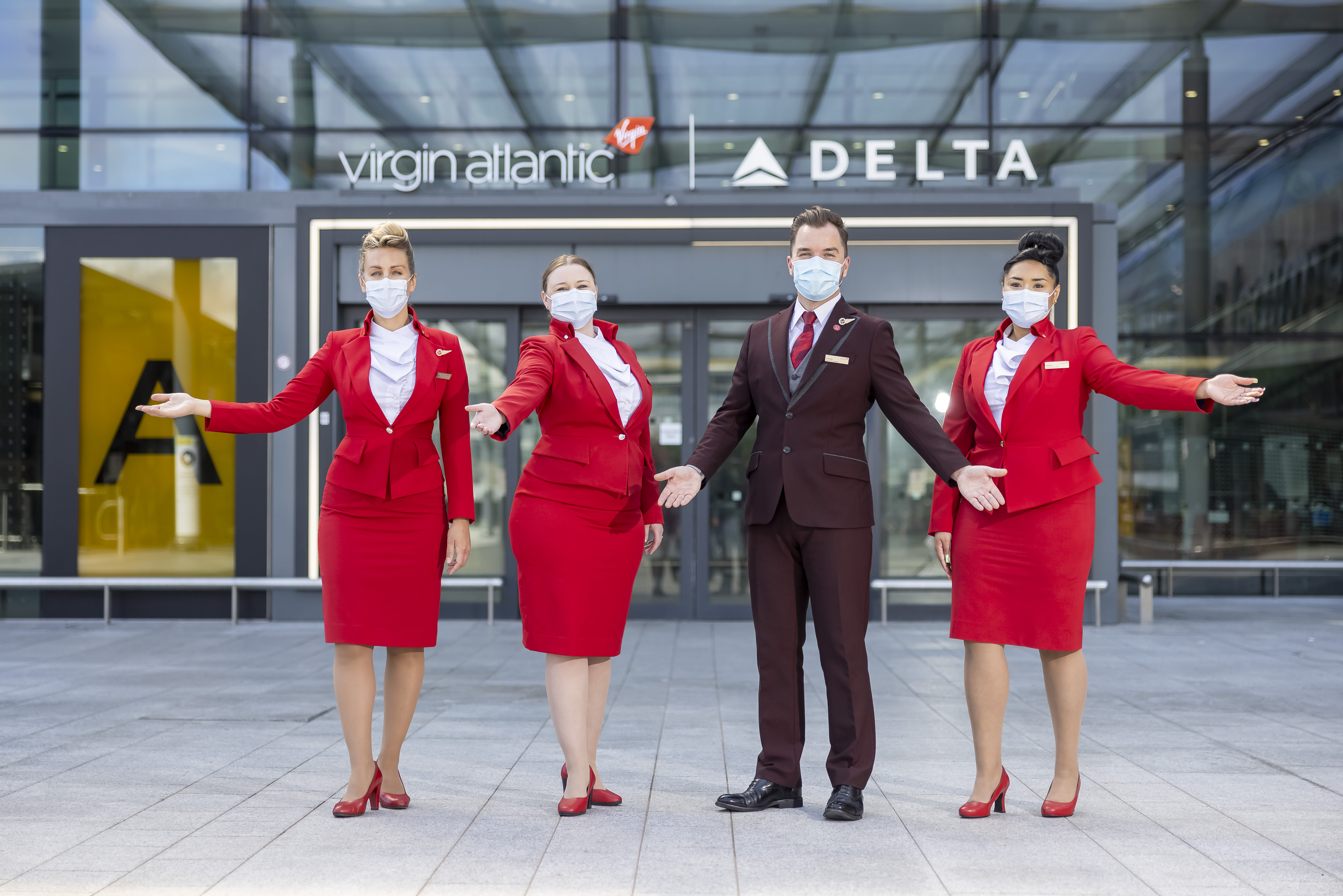 Virgin Atlantic cabin crew stand outside Virgin Atlantic and Delta Air Lines' entrance to London Heathrow Terminal 3