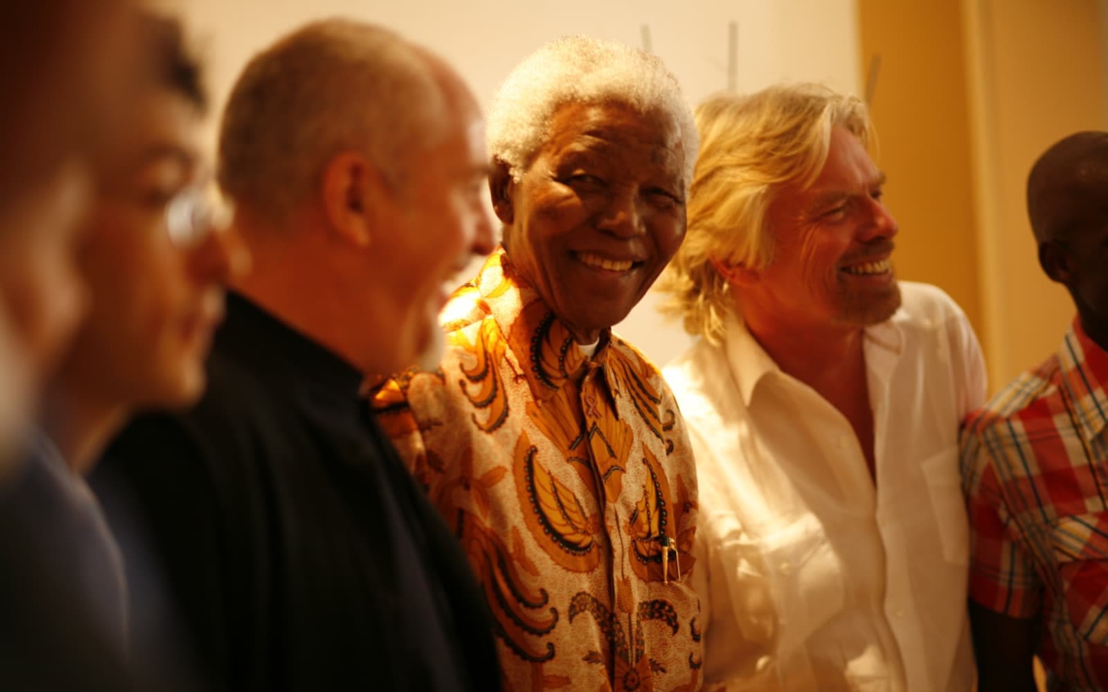 Richard Branson standing next to Nelson Mandela and others