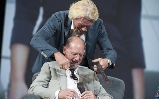 Richard Branson cutting a tie off the Delta CEO