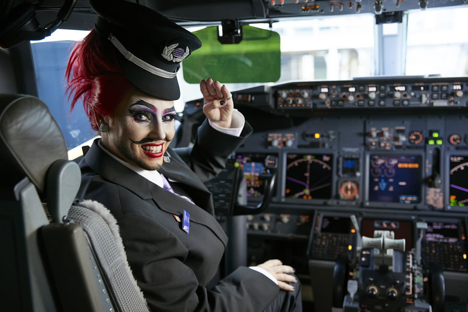 Drag Queen Sexy Galexy dressed as a pilot sitting in a cockpit