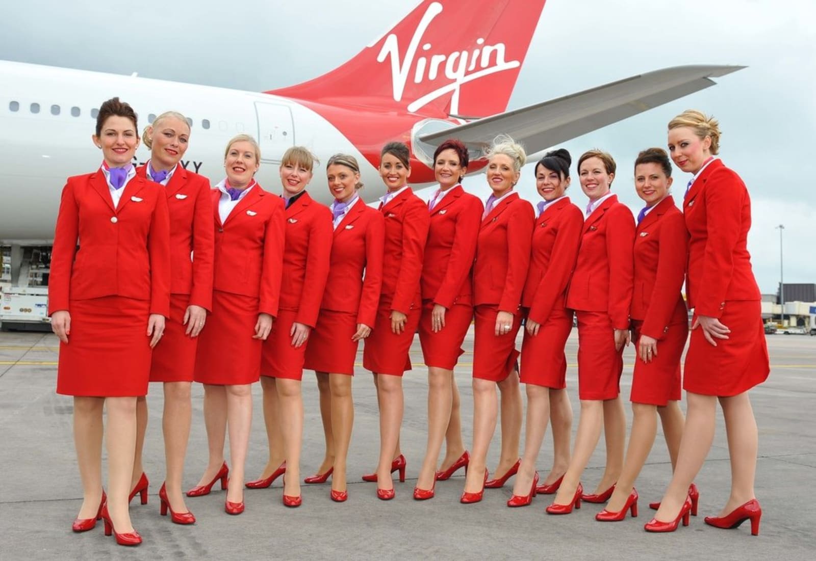 12 members of Virgin Atlantic cabin crew wearing the uniform designed by John Rocha