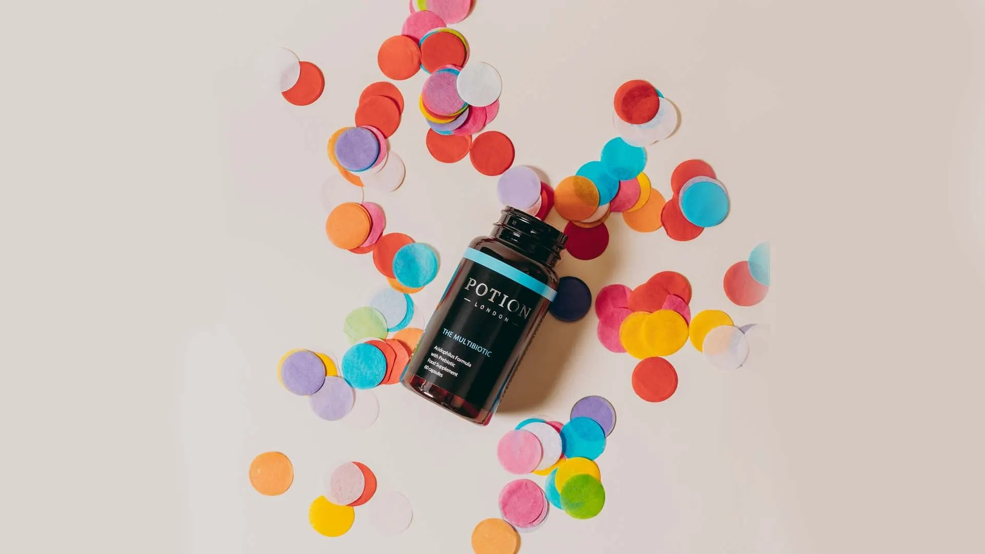 A bottle of Potion London's multibiotic supplement surrounded by confetti