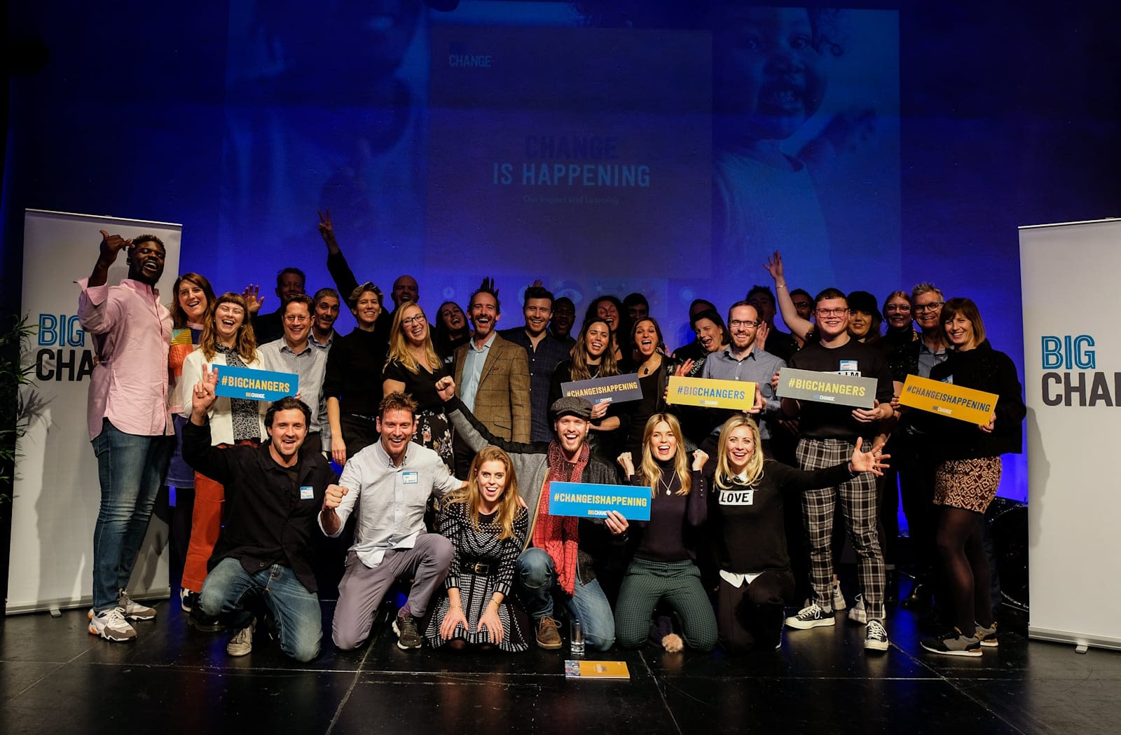 Holly, Sam and Bellie Branson with Princess Beatrice and a large group of people on stage smiling and looking at the camera