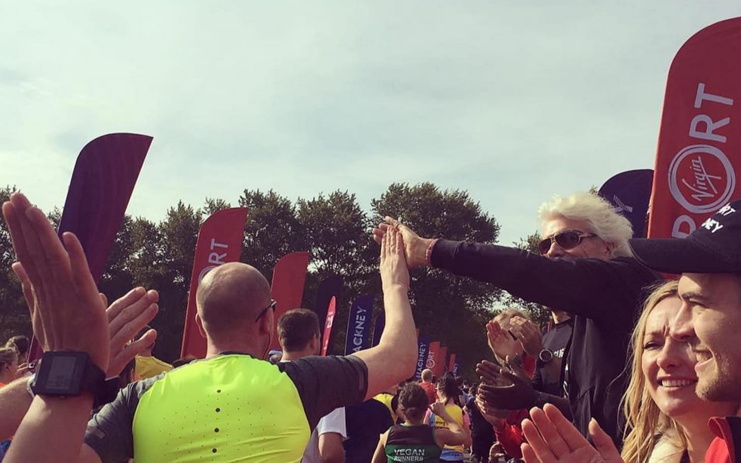 Richard Branson giving a runner a high five at the Virgin Sport Hackney starting line