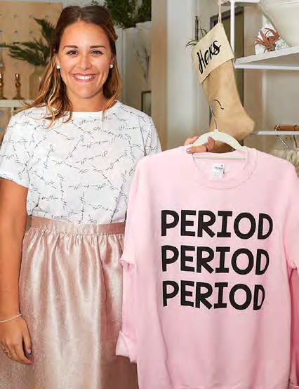 Virgin Radio London DJ Rachel Ettinger holds a sweatshirt that reads "Period Period Period"