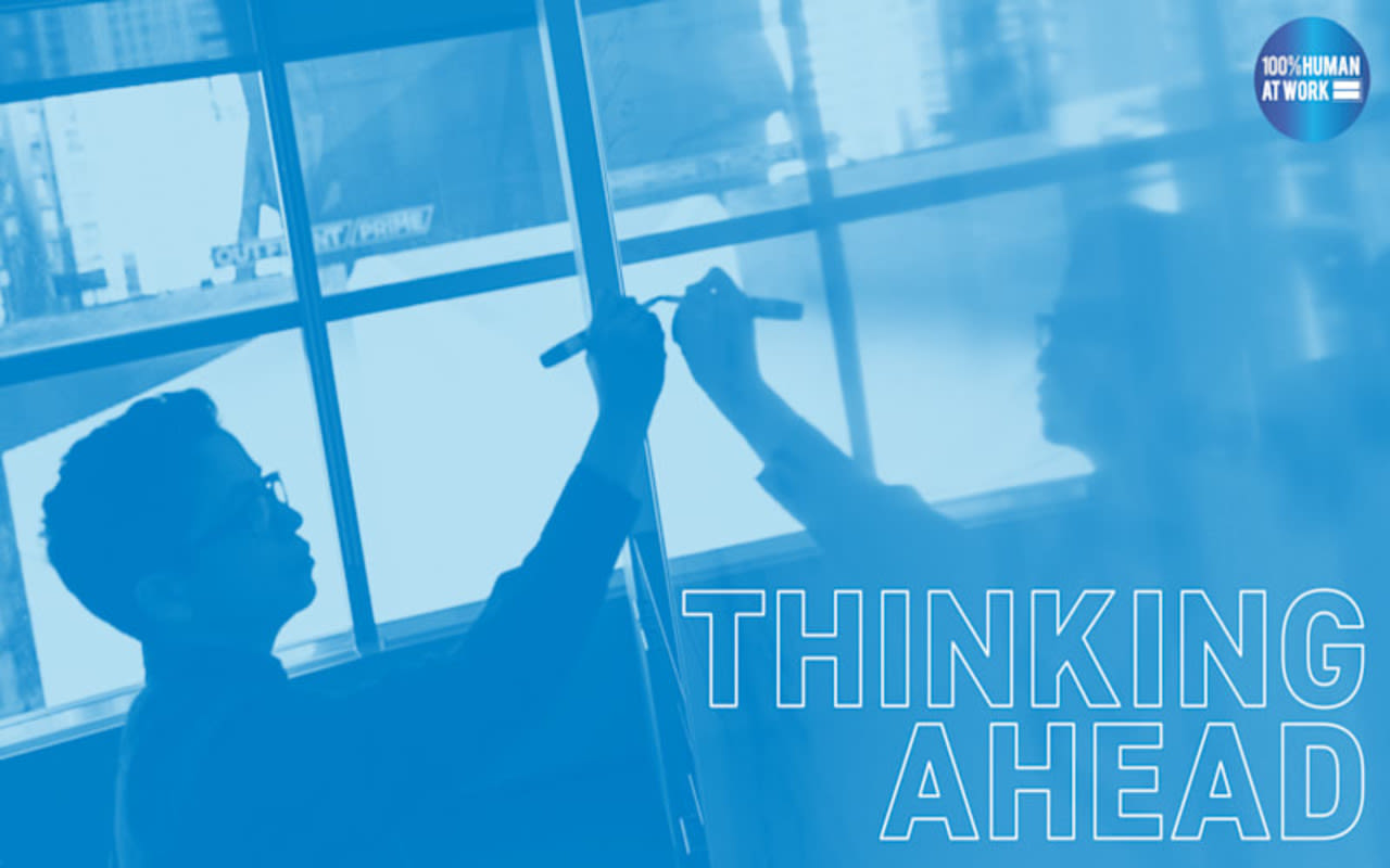 Blue image of a man writing on a white board