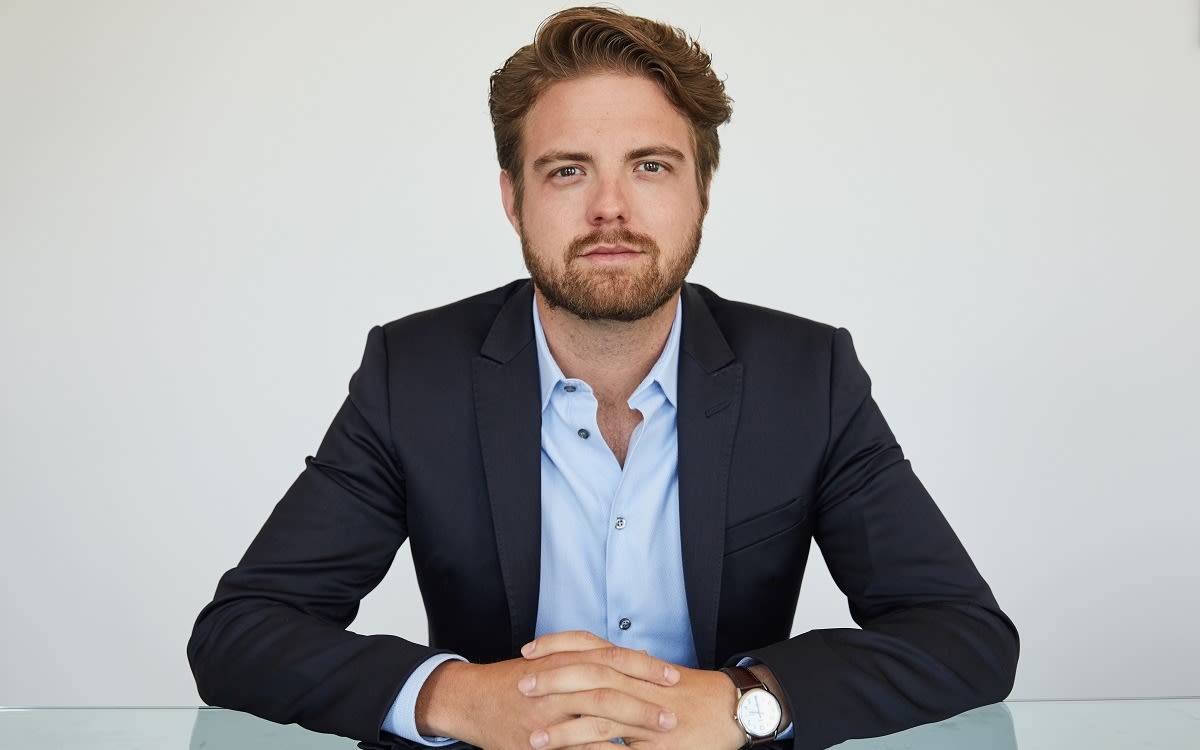 Peter Smith, sitting at a table, looking straight into the camera