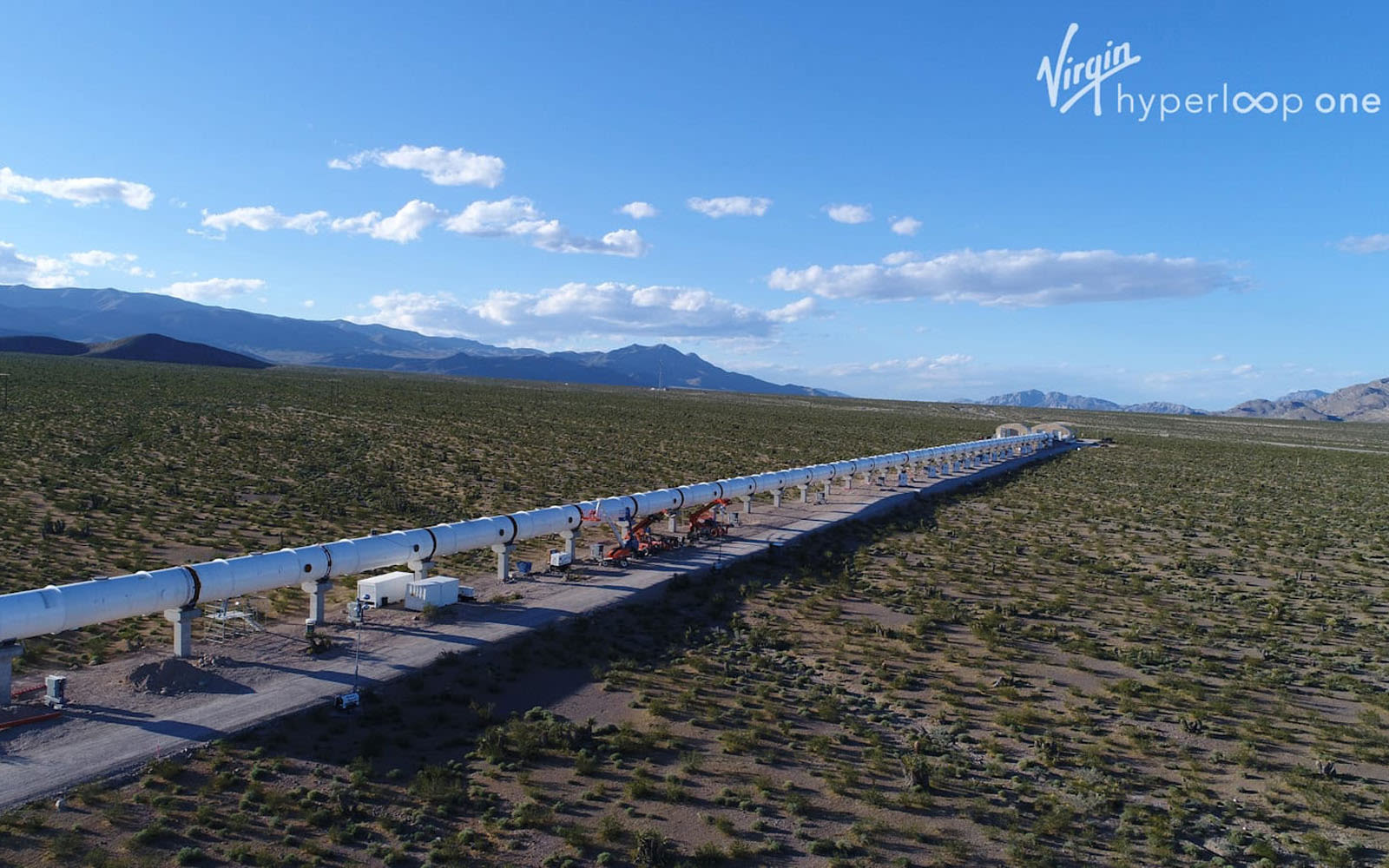 Virgin Hyperloop one cylinder tube track going through an empty field 