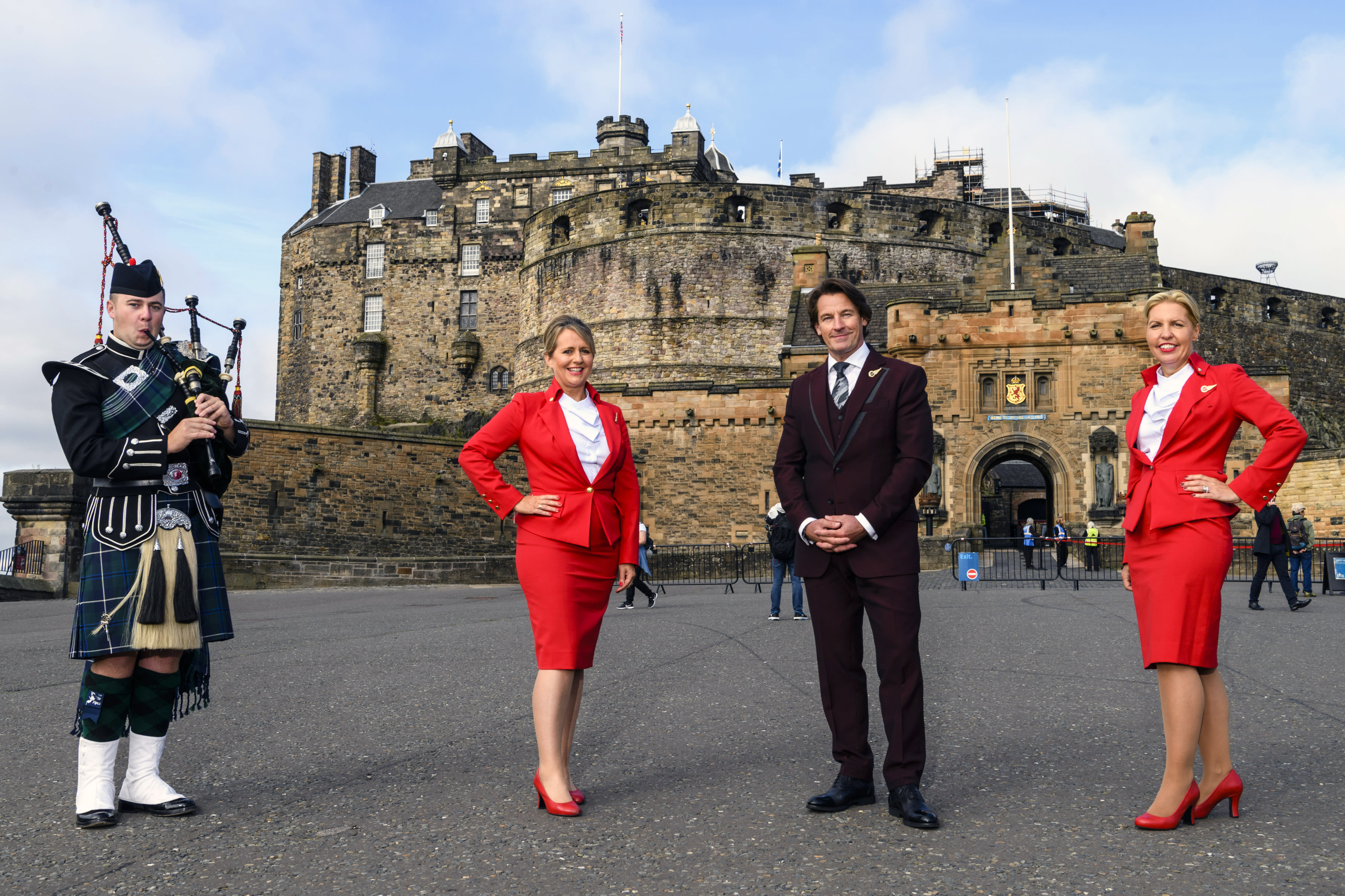 Virgin Atlantic cabin crew stand with a piper at Edinburgh Castle 