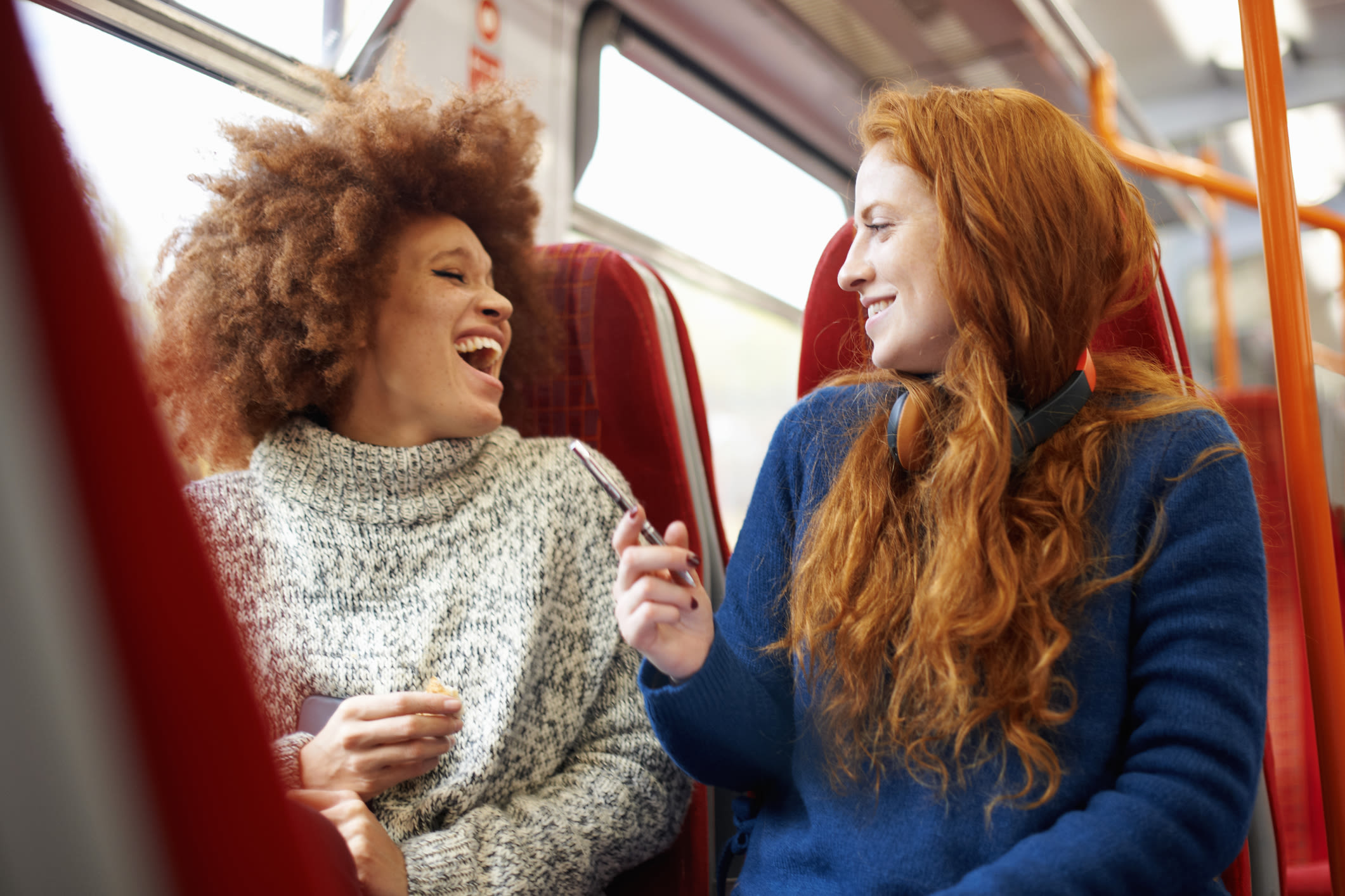 Two women laughing on a train