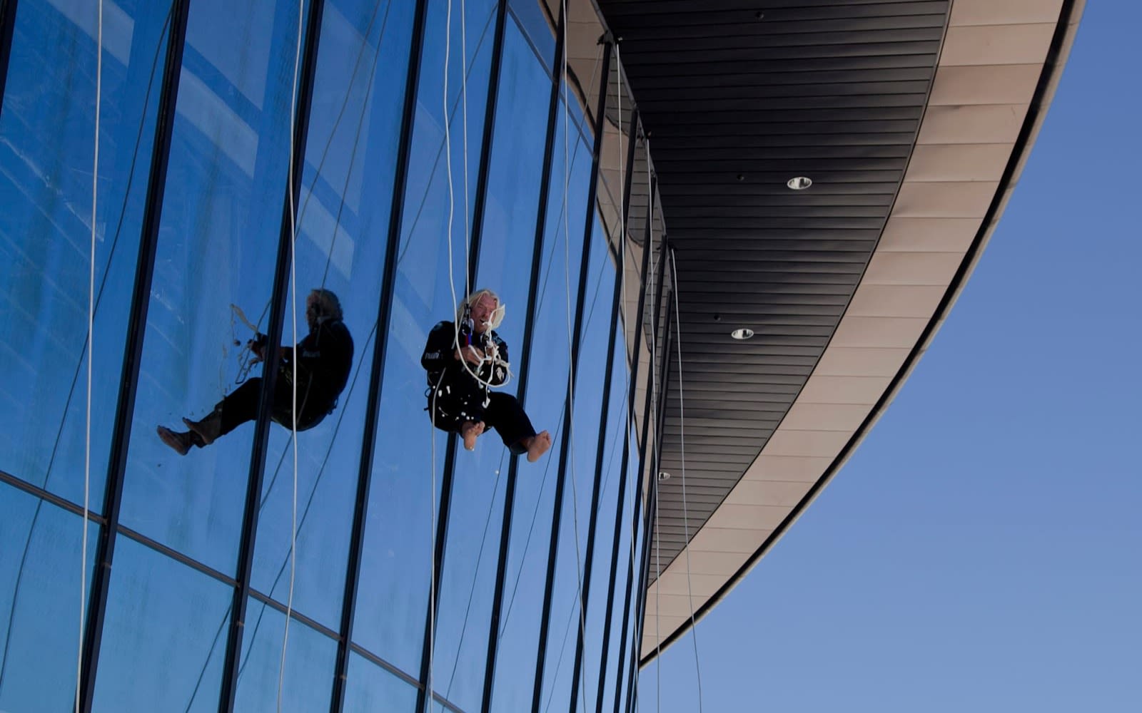 Richard Branson abseiling down a glass building